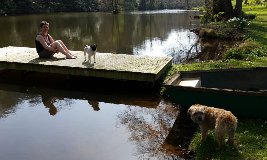 two dogs and a woman on a jetty